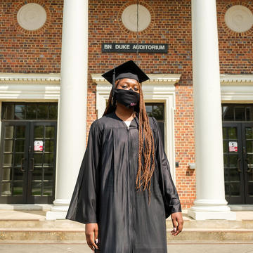 Graduate standing in front of historic building.