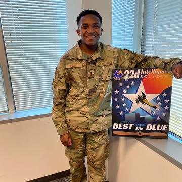 Brandon Peay holding a "Best in Blue" award from the 22nd Intelligence Squadron