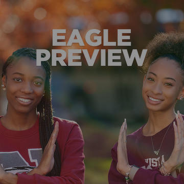two nccu students holding up the eagle sign with the words "eagle preview" between them