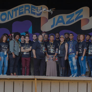 Monterrey Jazz Festival Attendees with banner behind them