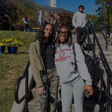 Two students smiling on the stairs
