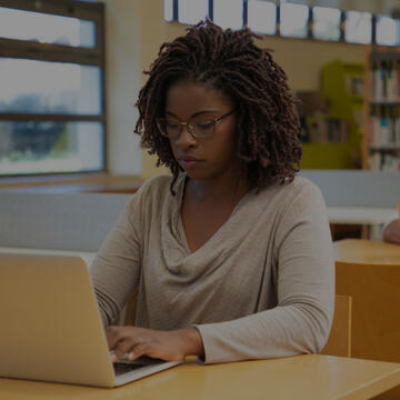 Student sitting at a desk and using a laptop