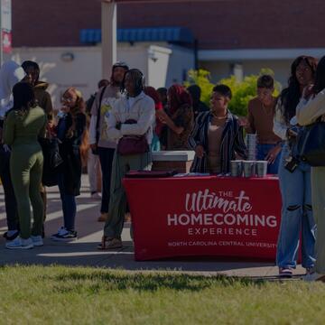 People standing around a Homecoming table
