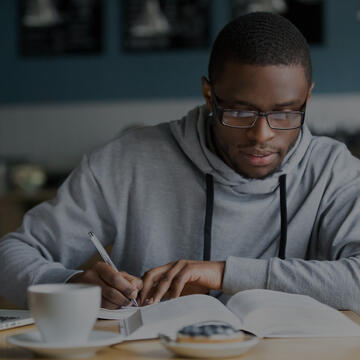 Man sitting in front of a computer and writing