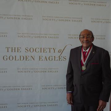 man standing in front of Society of Golden Eagles backdrop